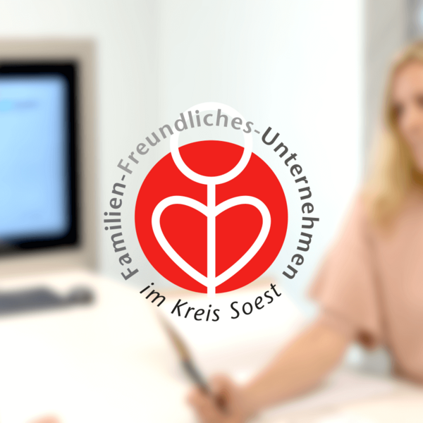 Qualitätssiegel für familienfreundliches Unternehmen im Vordergrund mit Gespräch im Büro zwischen Mann und Frau unscharf im Hintergrund dargestellt 